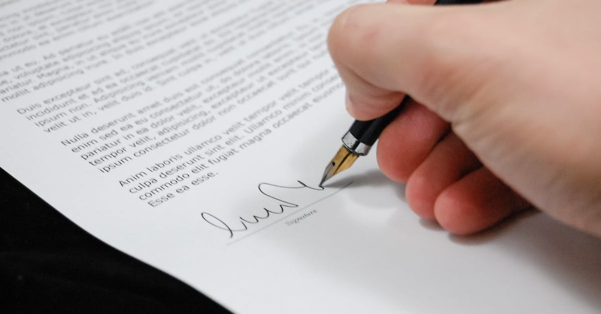 Close-up of a hand signing a legal document with a fountain pen, symbolizing signature and agreement.