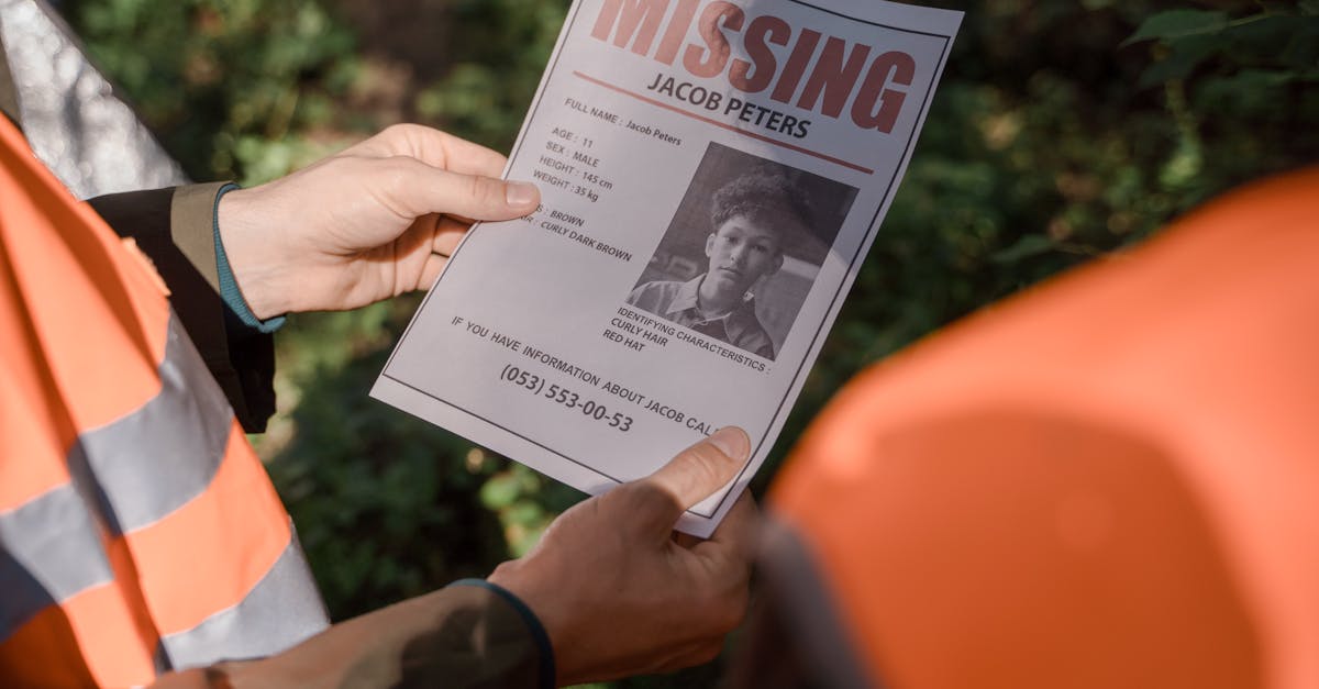 Hands holding a missing person flyer during a search operation in a forest setting, highlighting teamwork and urgency.