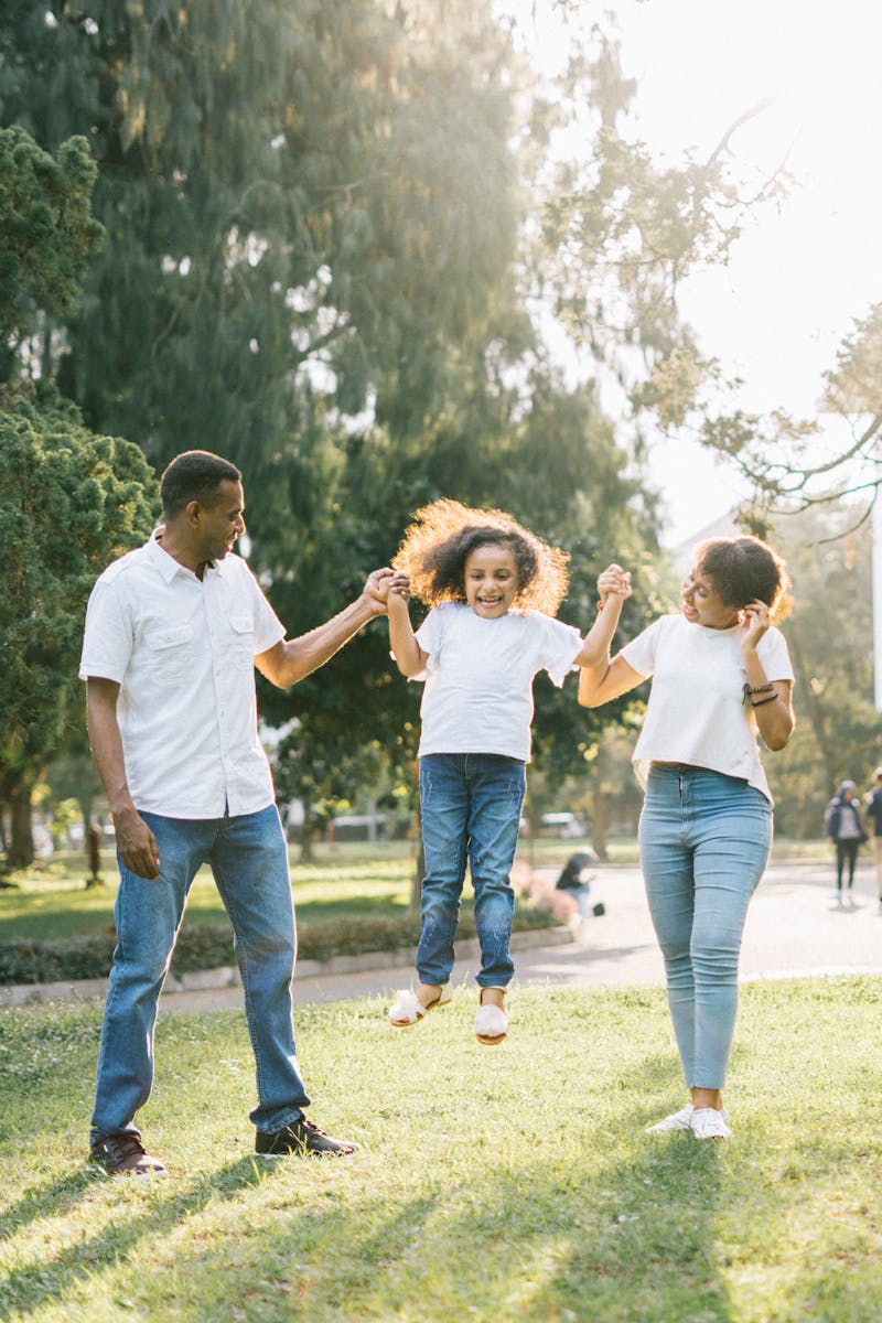 Joyful family enjoying a playful day at the park, embracing love and togetherness under the summer sun.