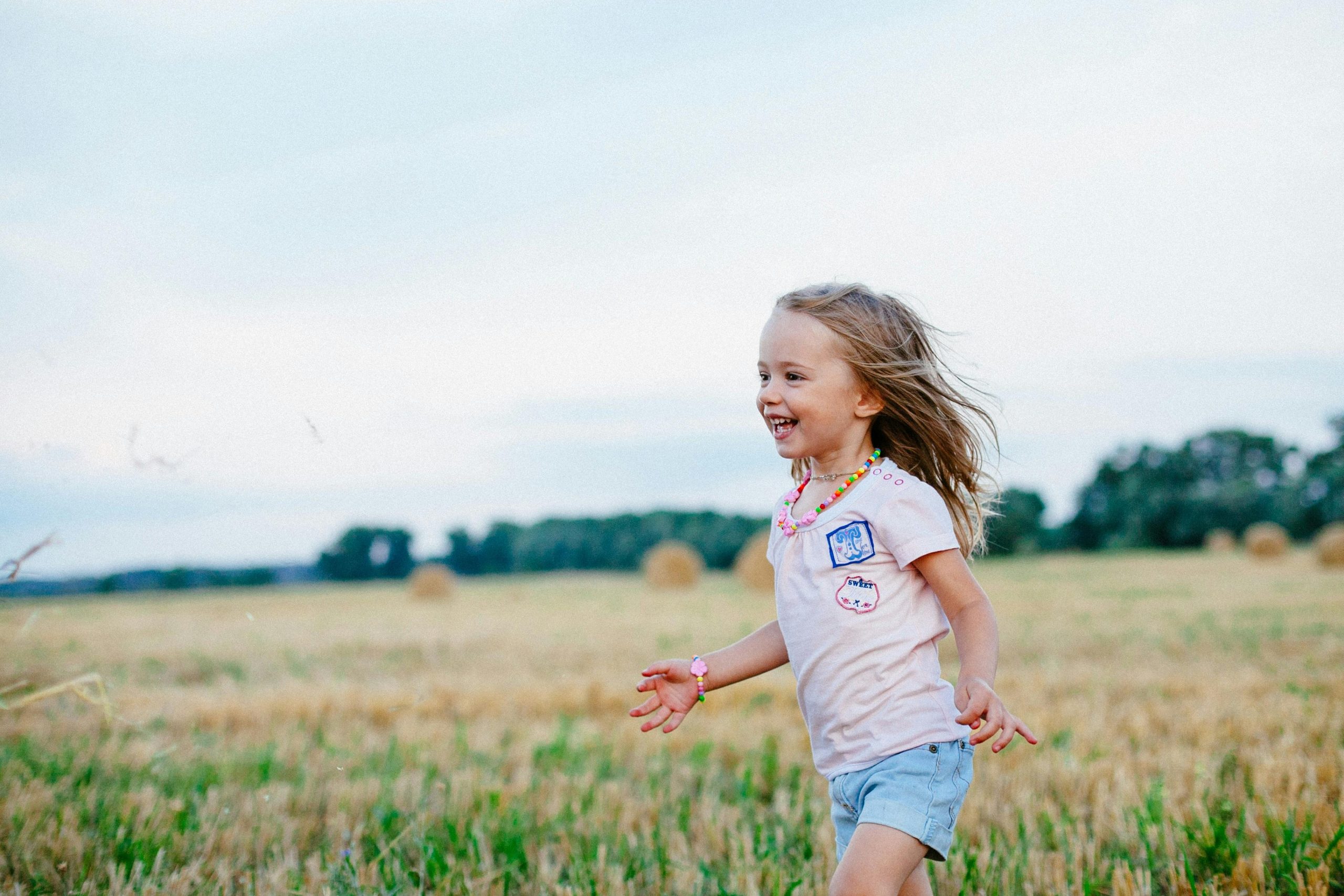 A joyful child running freely through a summer field, embracing the spirit of fun and freedom.