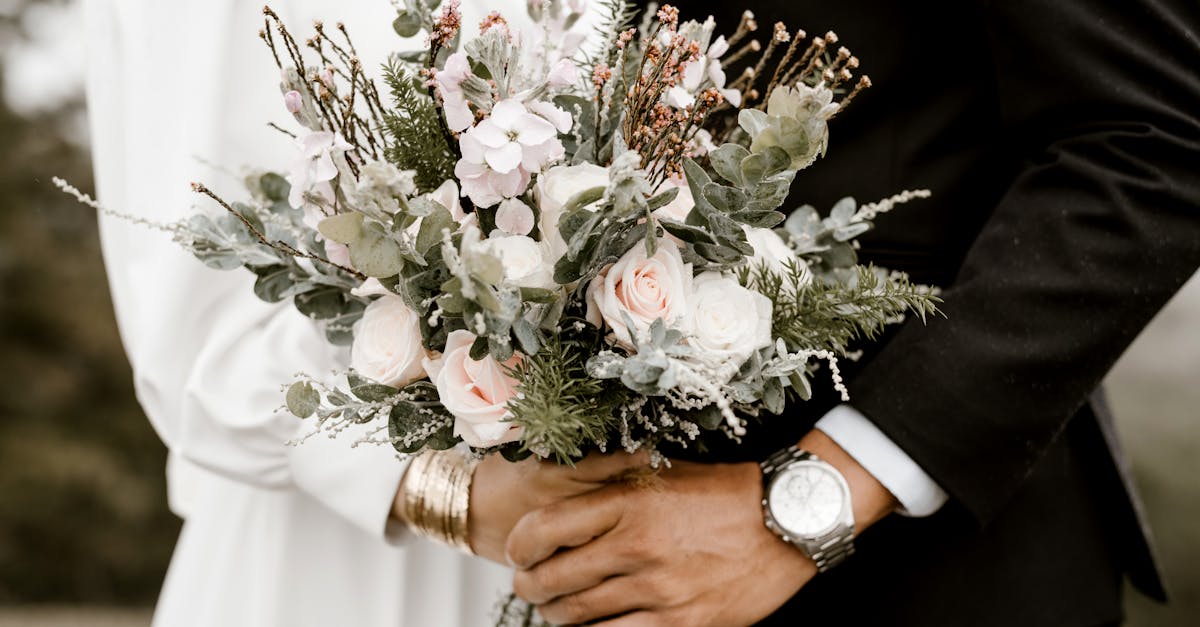 Close-up of a wedding bouquet held by bride and groom, showcasing romance and elegance.