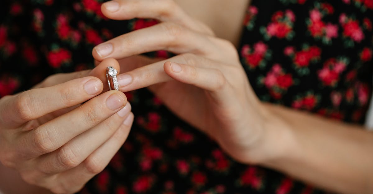 Close-up of a woman placing a diamond ring on her finger, showcasing elegance and luxury.