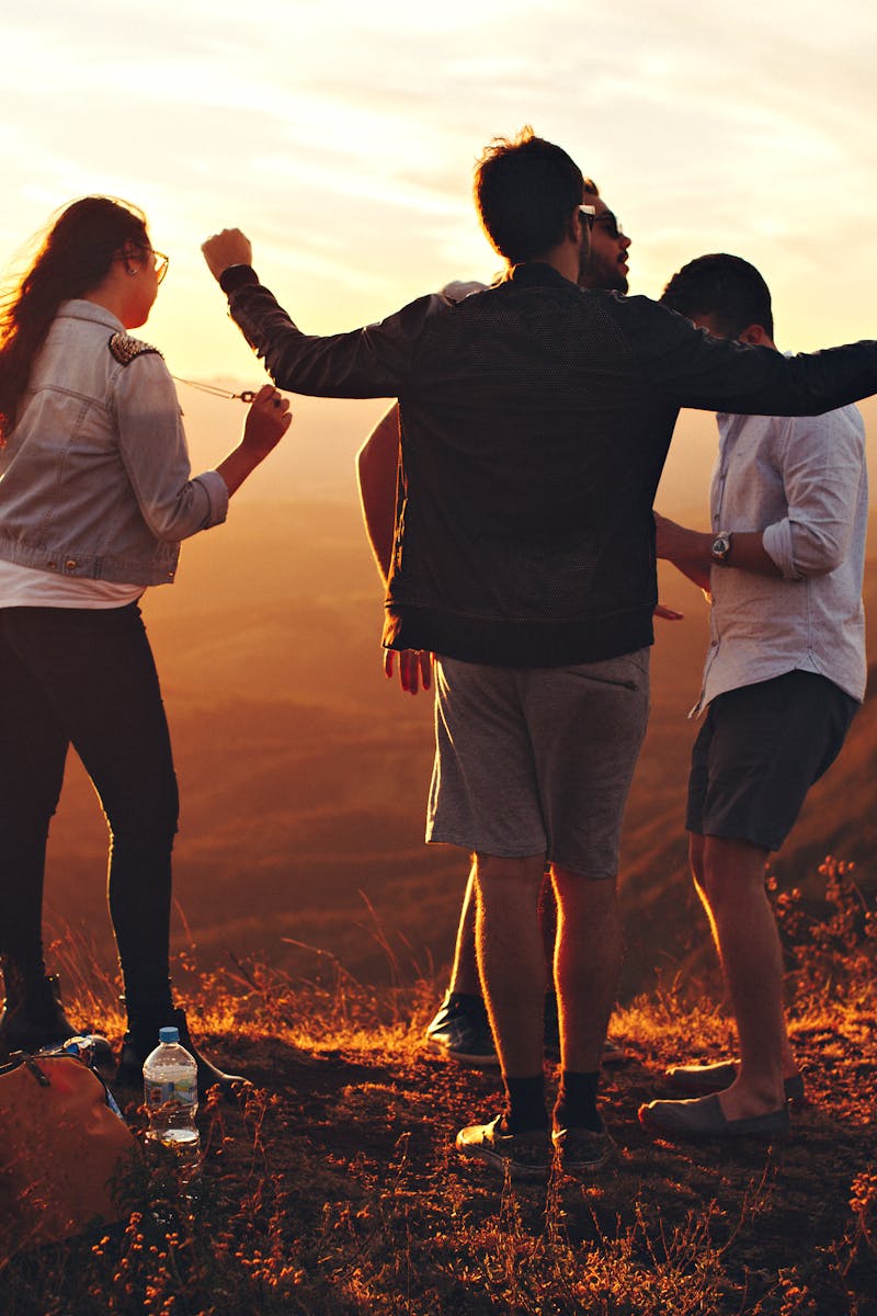 Joyful group of young adults enjoying a sunset view in a mountainous landscape in Brazil.