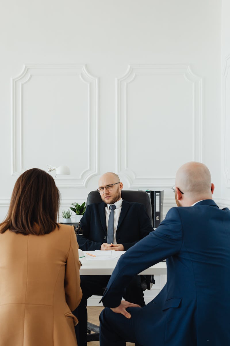 A lawyer consults a couple on divorce proceedings in an elegant office setting.